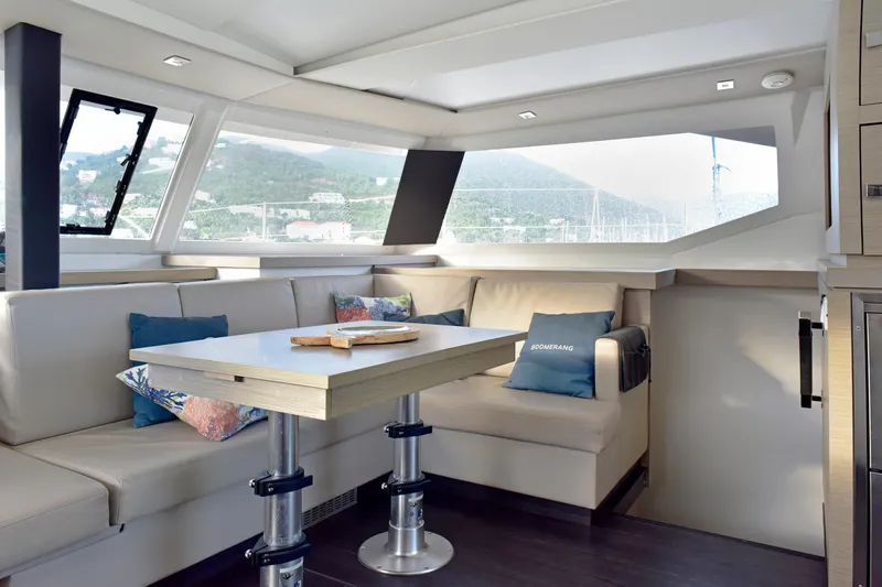 Boomerang Yacht Photos Pics Luxurious interior of 2022 Fountaine Pajot Astrea 42 catamaran with elegant seating and panoramic windows.