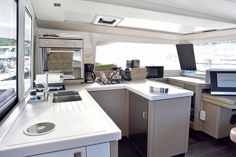 Boomerang Yacht Photos Pics Modern kitchen interior of 2022 Fountaine Pajot Astrea 42 catamaran with appliances and sleek design.