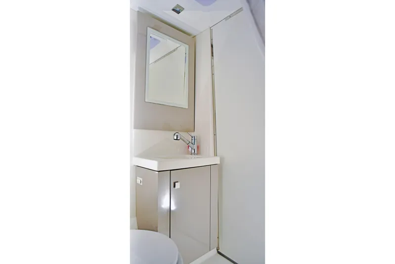 Boomerang Yacht Photos Pics Bathroom interior of 2022 Fountaine Pajot Astrea 42 catamaran, featuring modern sink and mirror.