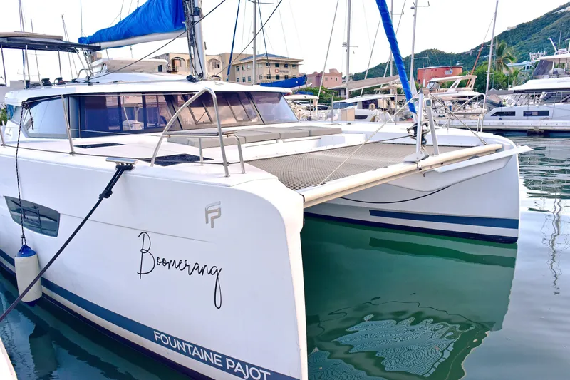 Boomerang Yacht Photos Pics 2022 Fountaine Pajot Astrea 42 catamaran docked in marina, featuring sleek design and spacious deck.