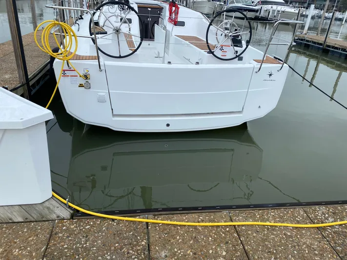 Job Site Yacht Photos Pics 2023 Jeanneau Sun Odyssey 380 docked, featuring dual steering wheels and a clean white hull.