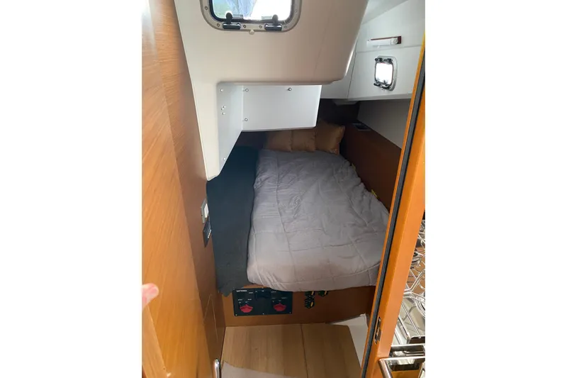 Job Site Yacht Photos Pics Cozy cabin interior of 2023 Jeanneau Sun Odyssey 380 sailboat with bed and porthole.