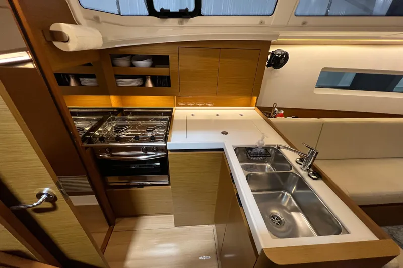 Job Site Yacht Photos Pics Modern kitchen interior of 2023 Jeanneau Sun Odyssey 380 yacht, featuring sleek design and amenities.
