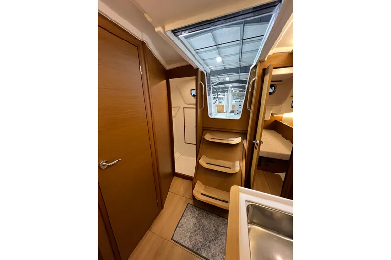 Job Site Yacht Photos Pics Interior of 2023 Jeanneau Sun Odyssey 380 yacht, featuring wooden cabinetry and modern design.