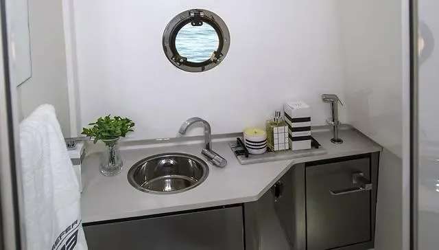  Yacht Photos Pics Modern bathroom in 2025 Schaefer V33 yacht with sink, porthole, and sleek cabinetry.