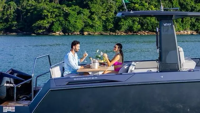  Yacht Photos Pics Couple enjoying drinks on a 2025 Schaefer V33 yacht, surrounded by scenic water and greenery.