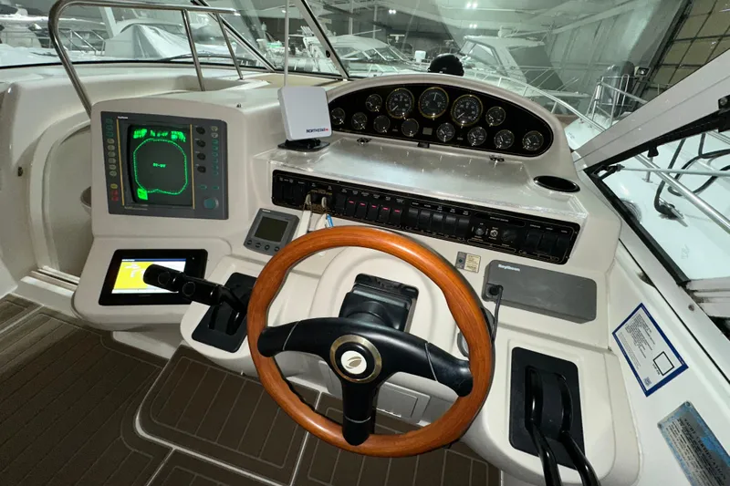  Yacht Photos Pics 1999 Cruisers Yachts 3870 Esprit helm with wooden steering wheel and navigation instruments.