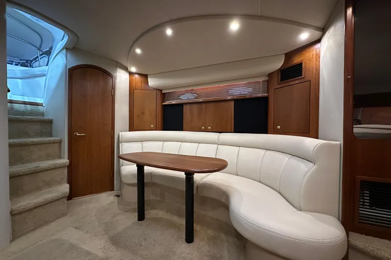  Yacht Photos Pics Luxurious interior of 1999 Cruisers Yachts 3870 Esprit with curved seating and wooden accents.
