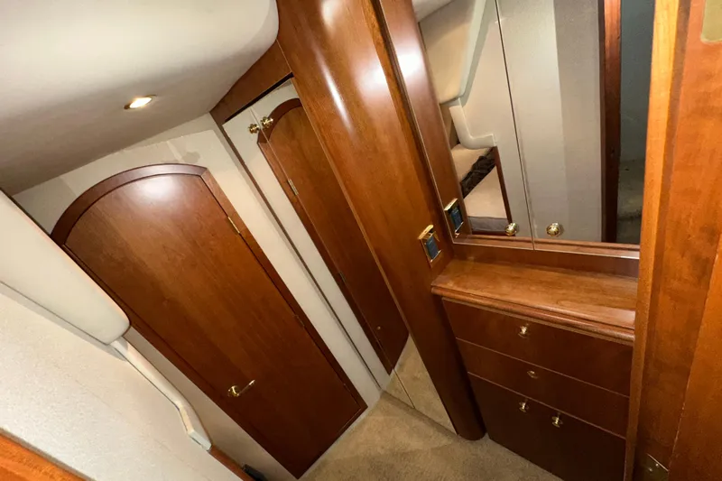  Yacht Photos Pics 1999 Cruisers Yachts 3870 Esprit interior with wooden cabinetry and mirrored dresser.