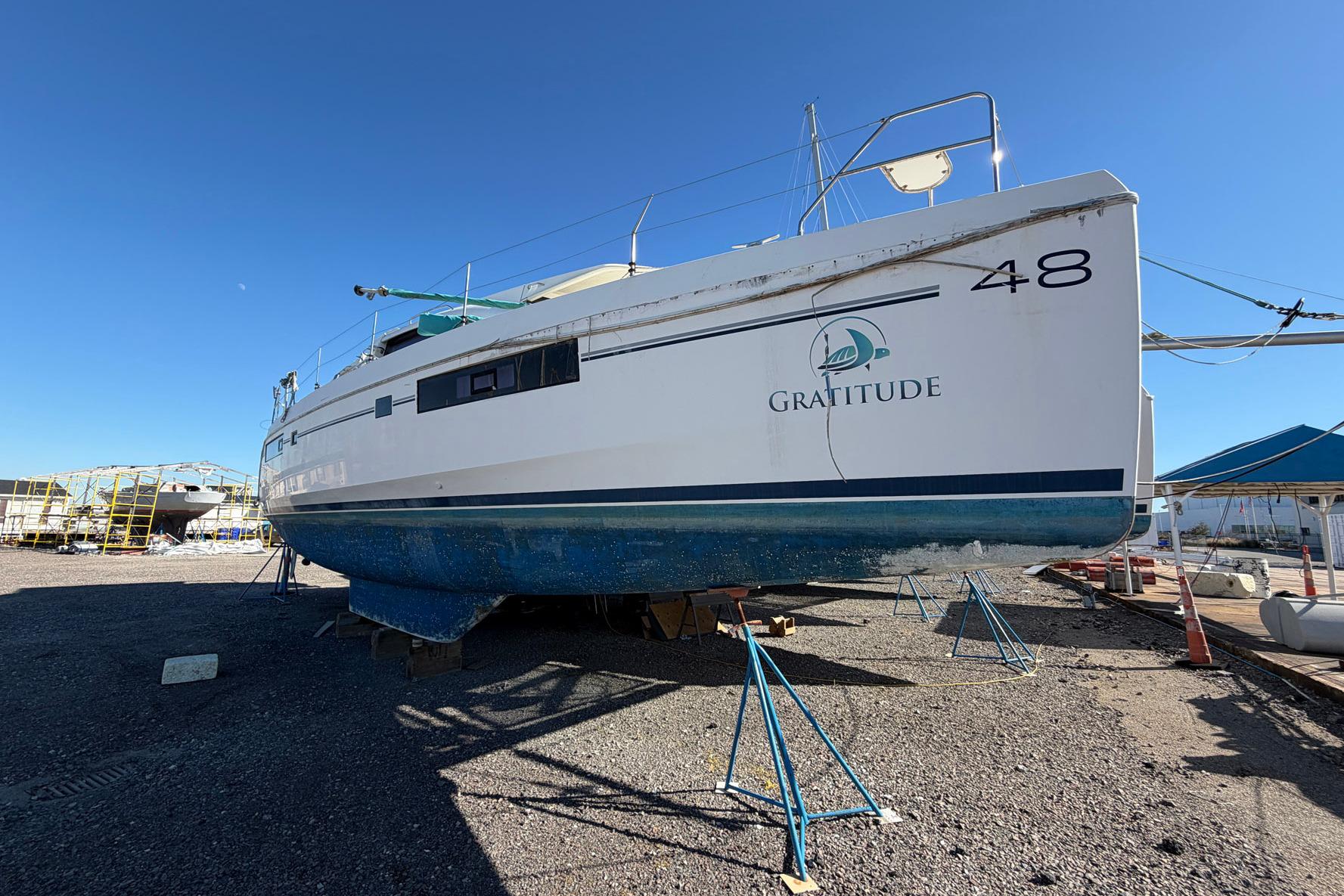 Leopard 48 catamaran, 2015 model, named "Gratitude" on dry dock under clear blue sky.