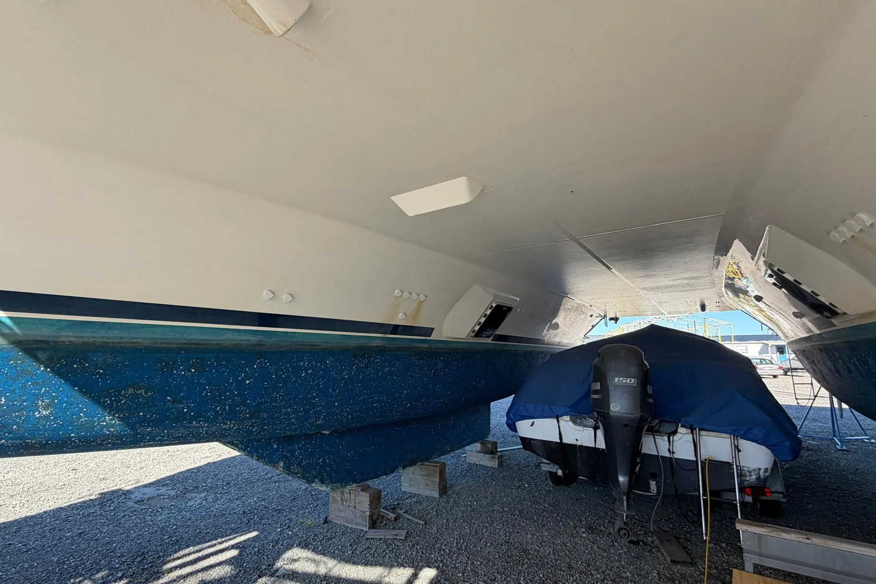 Underneath view of a 2015 Leopard 48 catamaran with a covered motorboat.