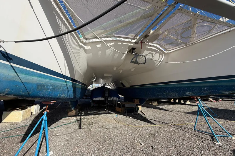 Gratitude Yacht Photos Pics Underneath view of a 2015 Leopard 48 catamaran on dry dock, supported by stands.