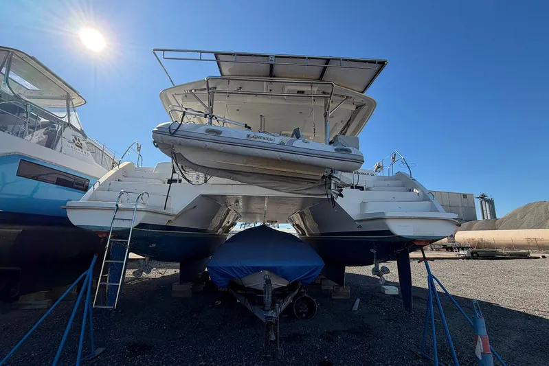 Gratitude Yacht Photos Pics 2015 Leopard 48 catamaran with dinghy, docked under clear blue sky.