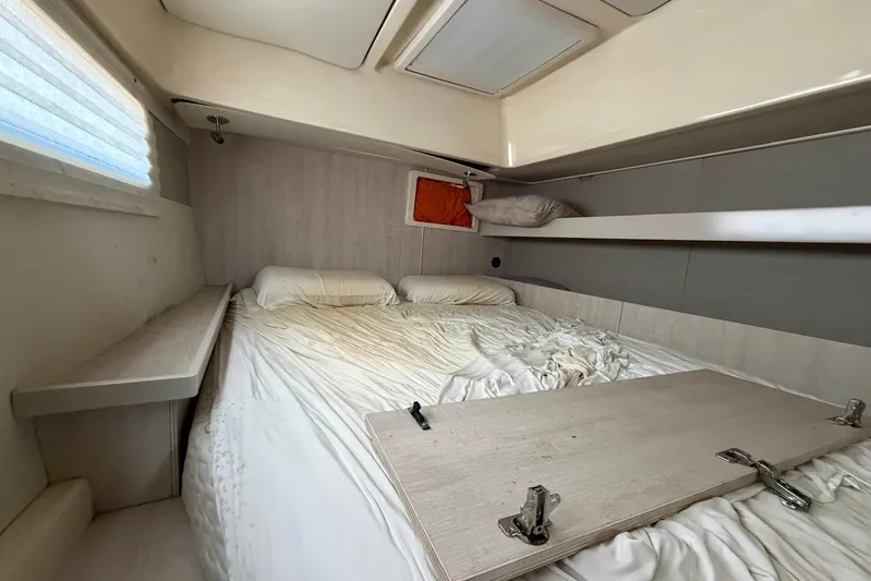 Gratitude Yacht Photos Pics Cozy cabin interior of 2015 Leopard 48 yacht with double bed and storage shelf.