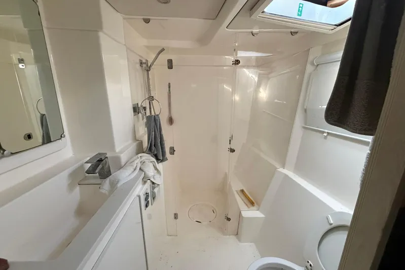 Gratitude Yacht Photos Pics Bathroom interior of a 2015 Leopard 48 yacht, featuring modern fixtures and white decor.