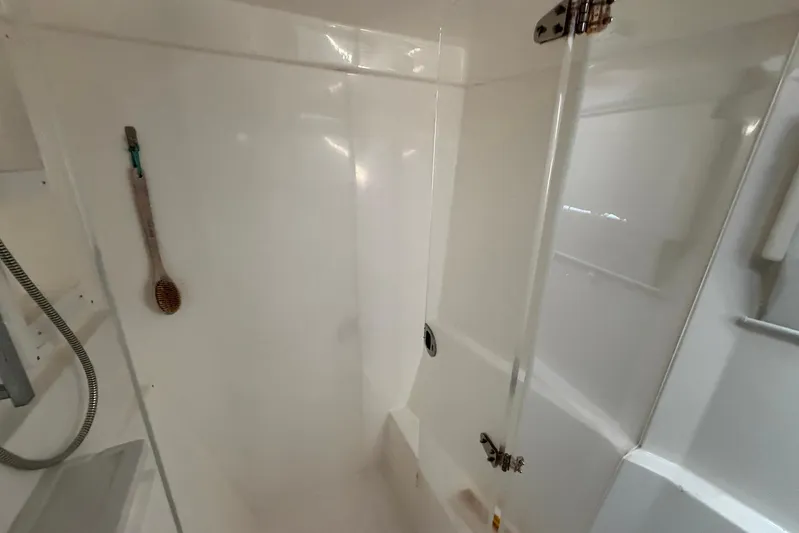 Gratitude Yacht Photos Pics Shower area in 2015 Leopard 48 yacht with glass door and wall-mounted brush.
