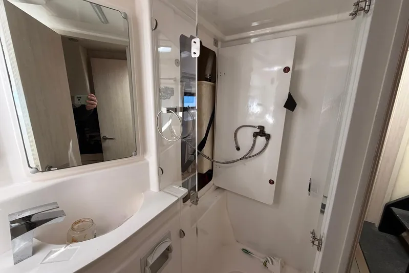 Gratitude Yacht Photos Pics Bathroom interior of a 2015 Leopard 48 yacht, featuring a mirror and sink.