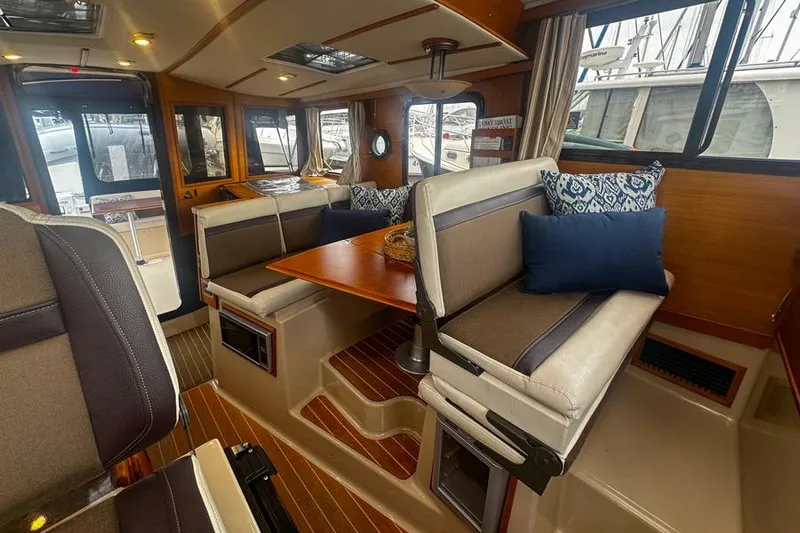 Mi Callao Yacht Photos Pics Interior of 2015 Ranger Tugs R-31 S with cozy seating and wooden accents.