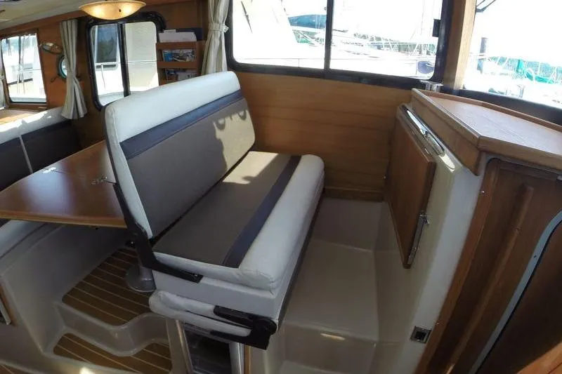 Mi Callao Yacht Photos Pics 2015 Ranger Tugs R-31S interior with dining area and wooden cabinetry.