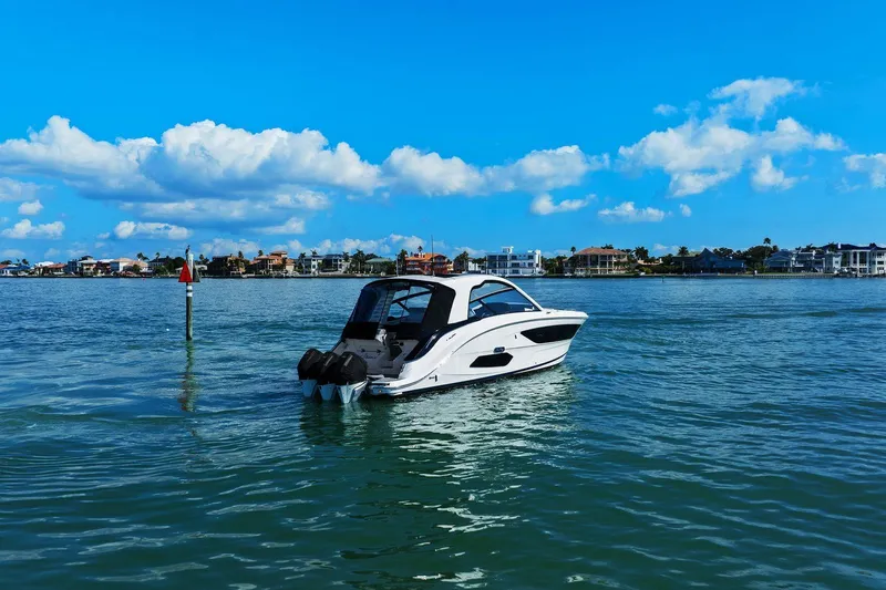  Yacht Photos Pics 2023 Sea Ray Sundancer 370 Outboard cruising on a sunny day with coastal homes in the background.