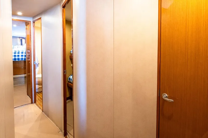 Geaux Time Yacht Photos Pics Interior hallway of a 2002 Viking 52 Convertible yacht with wooden doors and cozy lighting.