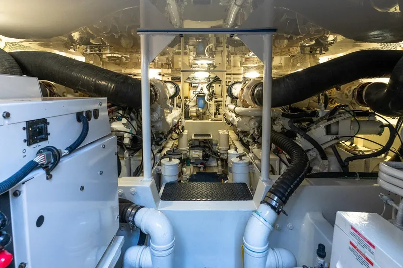 Geaux Time Yacht Photos Pics Engine room of a 2002 Viking 52 Convertible yacht, showcasing complex machinery and piping.