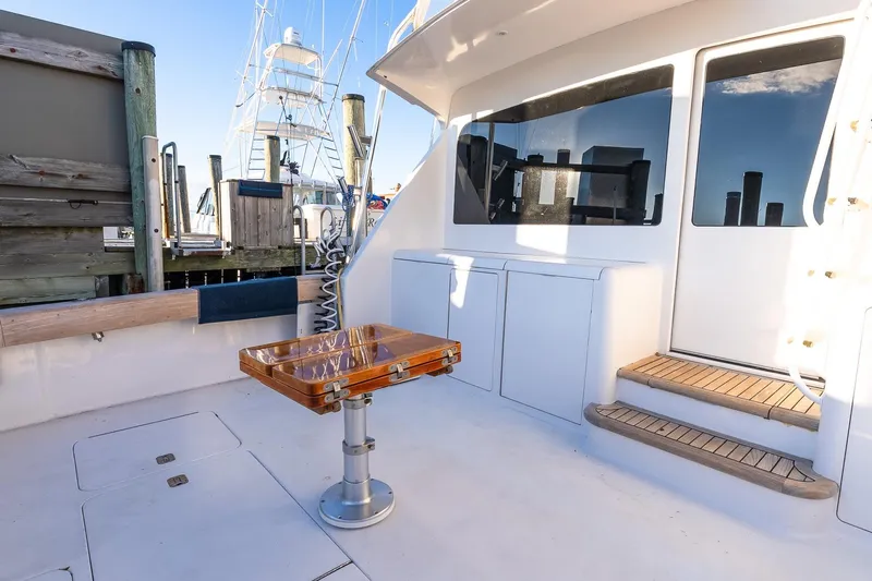 Geaux Time Yacht Photos Pics 2002 Viking 52 Convertible yacht deck with wooden table and marina view.