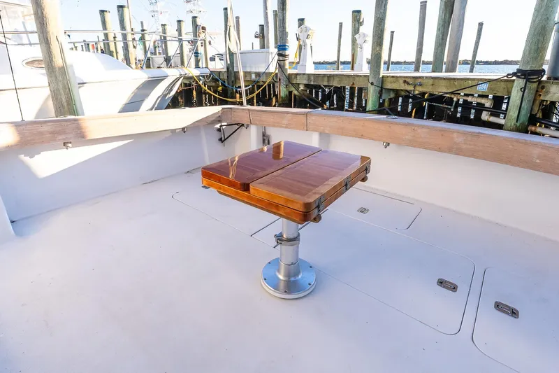 Geaux Time Yacht Photos Pics 2002 Viking 52 Convertible yacht deck with wooden table and marina view.