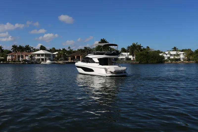 Ytf 002 Yacht Photos Pics 2024 Princess F45 yacht cruising on a serene waterway with waterfront homes in the background.