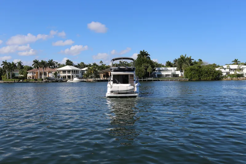 Ytf 002 Yacht Photos Pics 2024 Princess F45 yacht on a serene waterfront with palm trees and houses.