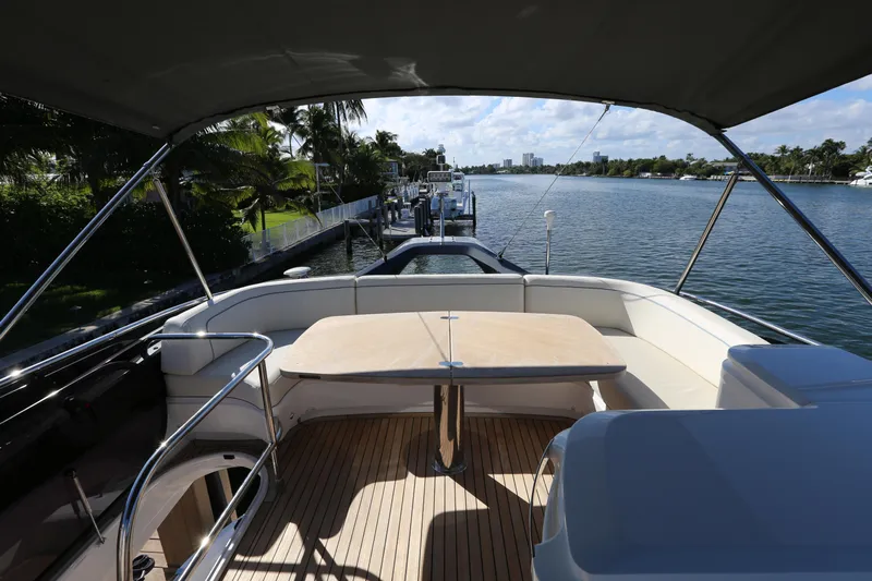 Ytf 002 Yacht Photos Pics 2024 Princess F45 yacht deck with seating, overlooking serene waterfront and lush greenery.