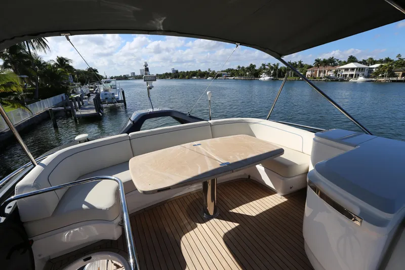 Ytf 002 Yacht Photos Pics 2024 Princess F45 yacht deck with seating and table, overlooking a scenic waterfront.