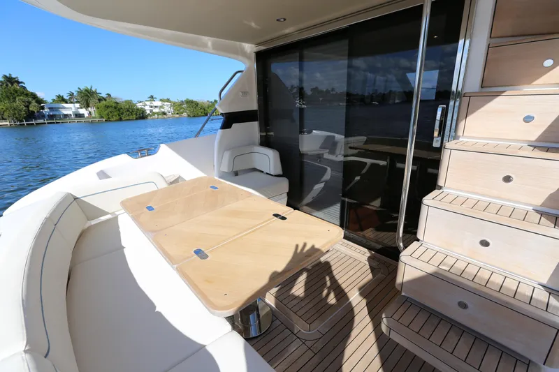 Ytf 002 Yacht Photos Pics 2024 Princess F45 yacht deck with seating, table, and stairs by the water.