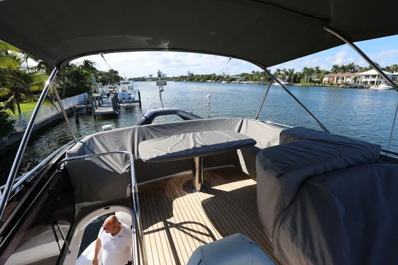 Ytf 002 Yacht Photos Pics 2024 Princess F45 yacht deck with covered seating, overlooking a scenic waterfront.