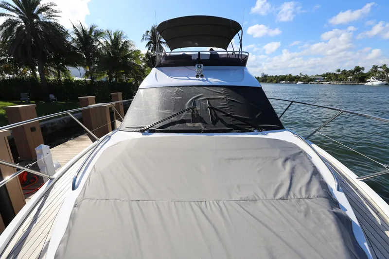 Ytf 002 Yacht Photos Pics 2024 Princess F45 yacht docked by palm trees, under a clear blue sky.