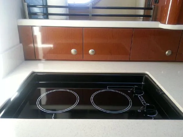 Blue Aye Yacht Photos Pics 2008 Sea Ray 330 Sundancer kitchen with electric stove and wooden cabinets.