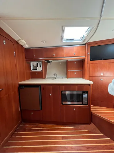  Yacht Photos Pics 2005 Tiara Yachts 3200 Open galley with microwave, mini-fridge, and wooden cabinetry.