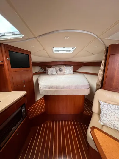  Yacht Photos Pics Luxurious cabin interior of a 2005 Tiara Yachts 3200 Open with cozy bed and wooden finishes.