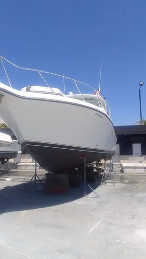  Yacht Photos Pics 2005 Tiara Yachts 3200 Open on dry dock under clear blue sky.