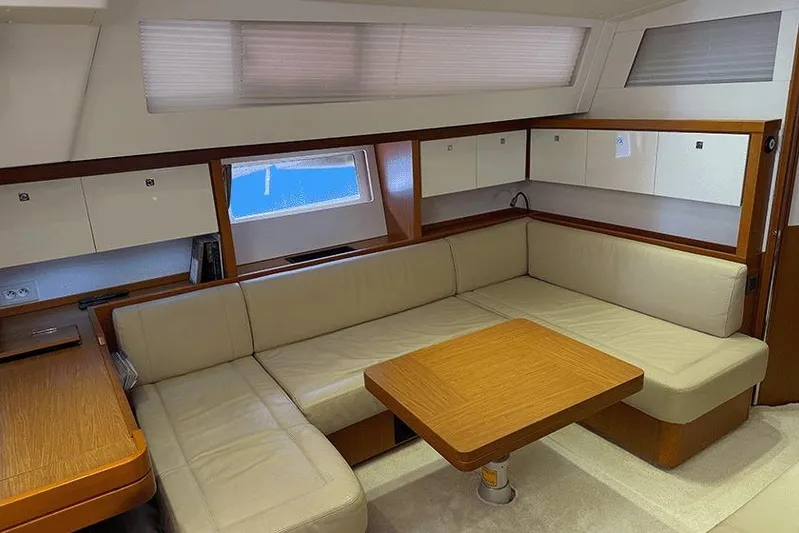  Yacht Photos Pics Luxurious interior of 2013 Beneteau Sense 55 yacht with beige seating and wooden table.