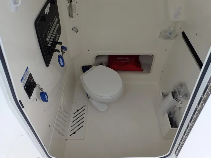  Yacht Photos Pics 2023 Boston Whaler 280 Outrage boat interior with a compact marine toilet.
