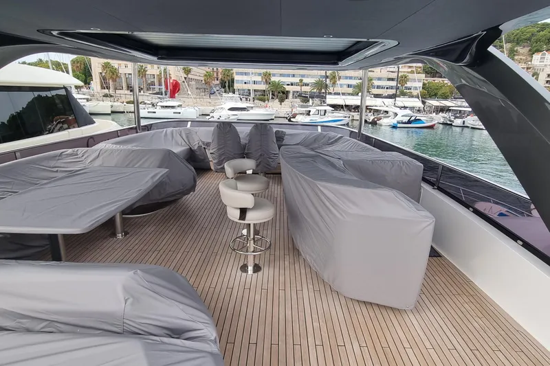  Yacht Photos Pics Luxurious 2022 Princess Y85 yacht deck with covered seating and scenic marina view.