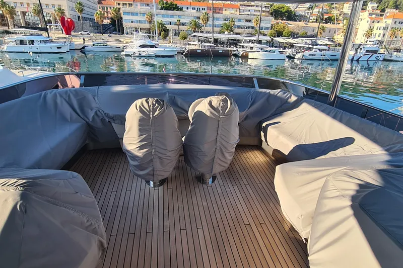  Yacht Photos Pics Luxurious 2022 Princess Y85 yacht deck with covered seating, docked in a scenic marina.