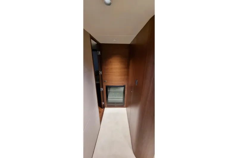  Yacht Photos Pics Luxurious hallway inside 2022 Princess Y85 yacht with wooden paneling and mini fridge.