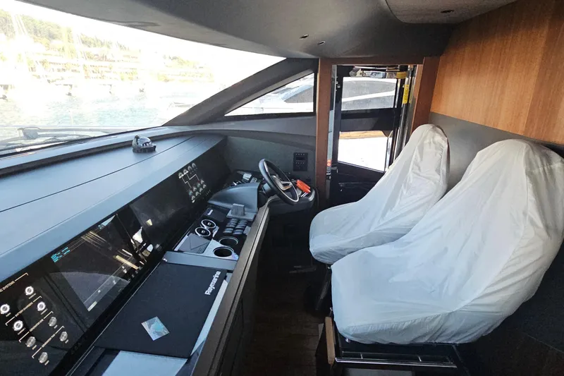  Yacht Photos Pics Interior view of 2022 Princess Y85 yacht cockpit with covered seats and advanced controls.