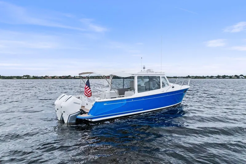 Tumalum Yacht Photos Pics 2023 MJM 35 boat on open water, featuring a sleek blue hull and twin engines.