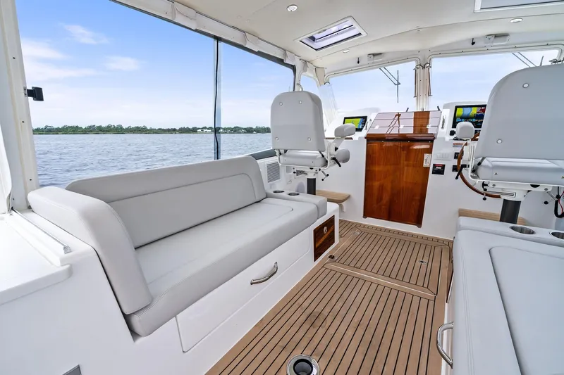Tumalum Yacht Photos Pics 2023 MJM 35 boat interior with modern seating and navigation equipment, overlooking calm waters.