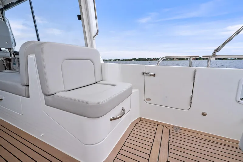 Tumalum Yacht Photos Pics 2023 MJM 35 boat interior with cushioned seating and teak flooring.