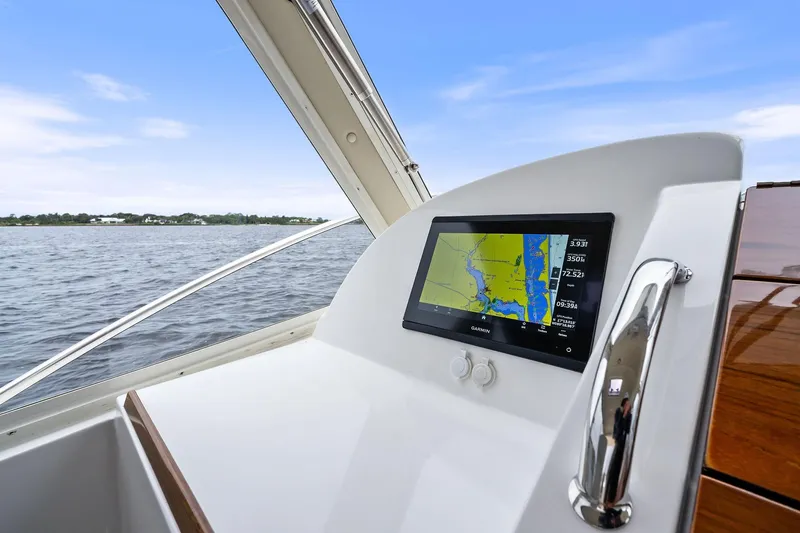 Tumalum Yacht Photos Pics 2023 MJM 35 boat dashboard with navigation screen, overlooking calm waters.