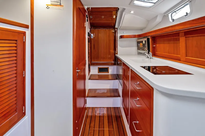 Tumalum Yacht Photos Pics Luxurious 2023 MJM 35 yacht interior with sleek wood finishes and modern kitchen amenities.